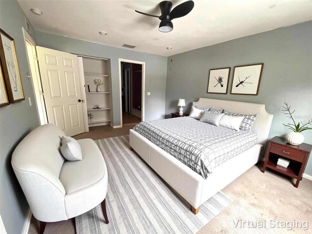 A bedroom features a bed, a small sofa, a nightstand, and built-in wall shelving — 731 LAKESIDE DRIVE, LARGO, FL