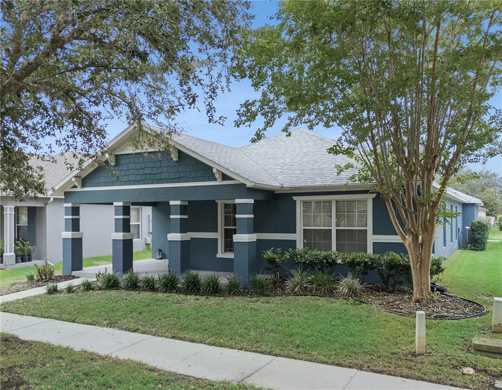 A blue single-story house with a front porch, white trim, and a shingled roof — 13736 PHOENIX DRIVE, ORLANDO, FL