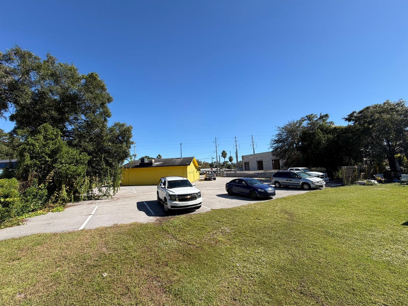 A parking lot with several parked cars sits in front of a yellow building — 8280 S Us Hwy 17 92, FL 32730, FL