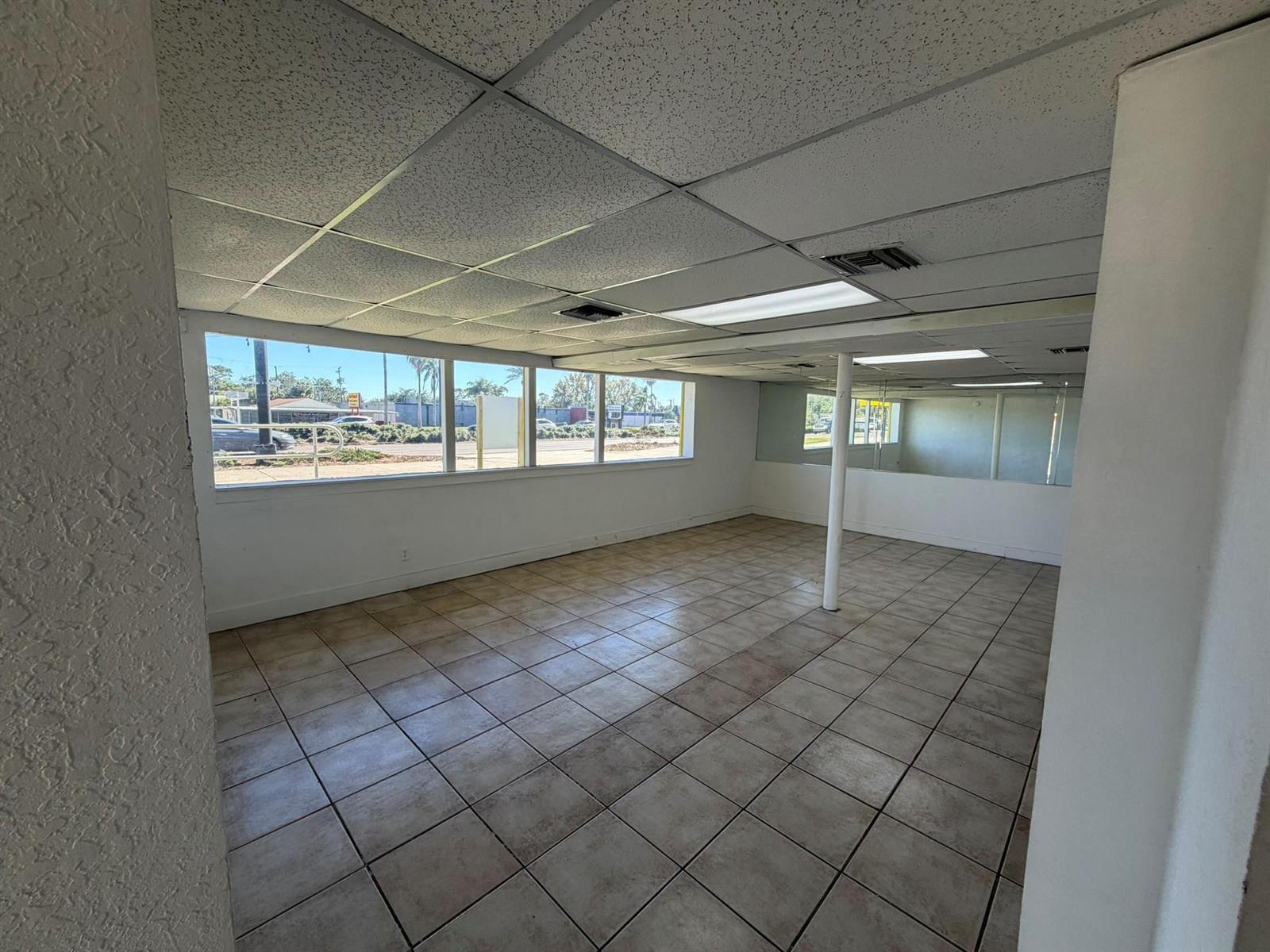 An empty commercial space with tiled floors, a drop ceiling, and large windows — 8280 S Us Hwy 17 92, FL 32730, FL