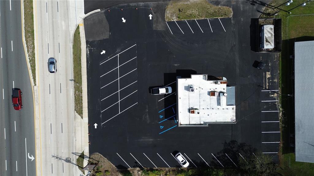An aerial view shows a commercial building with a parking lot and adjacent road — 201 US HIGHWAY 27 S, AVON PARK, FL