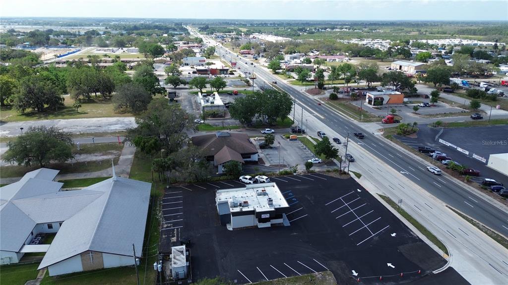 An aerial view shows a commercial building with a parking lot next to a church — 201 US HIGHWAY 27 S, AVON PARK, FL