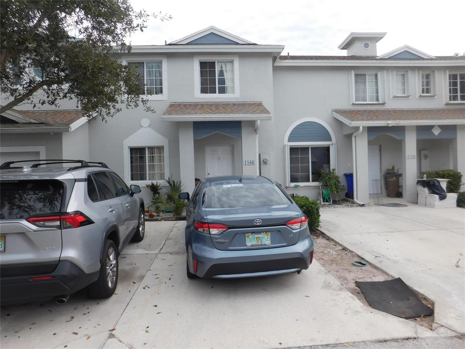 A two-story townhouse exterior with two parked cars in the driveway — 1106 SW 44th Way, Deerfield Beach FL 33442, DEERFIELD BEACH, FL