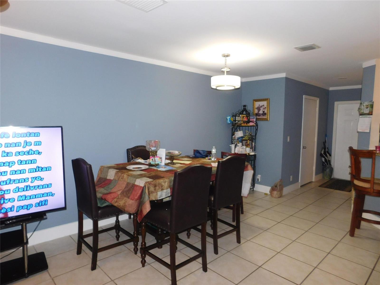 A dining area features a table with four chairs, blue walls, and tile flooring — 1106 SW 44th Way, Deerfield Beach FL 33442, DEERFIELD BEACH, FL