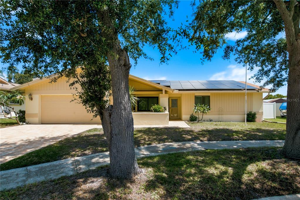A single-story house with a two-car garage, solar panels, and a paved driveway — 254 TIMBERVIEW DRIVE, SAFETY HARBOR, FL