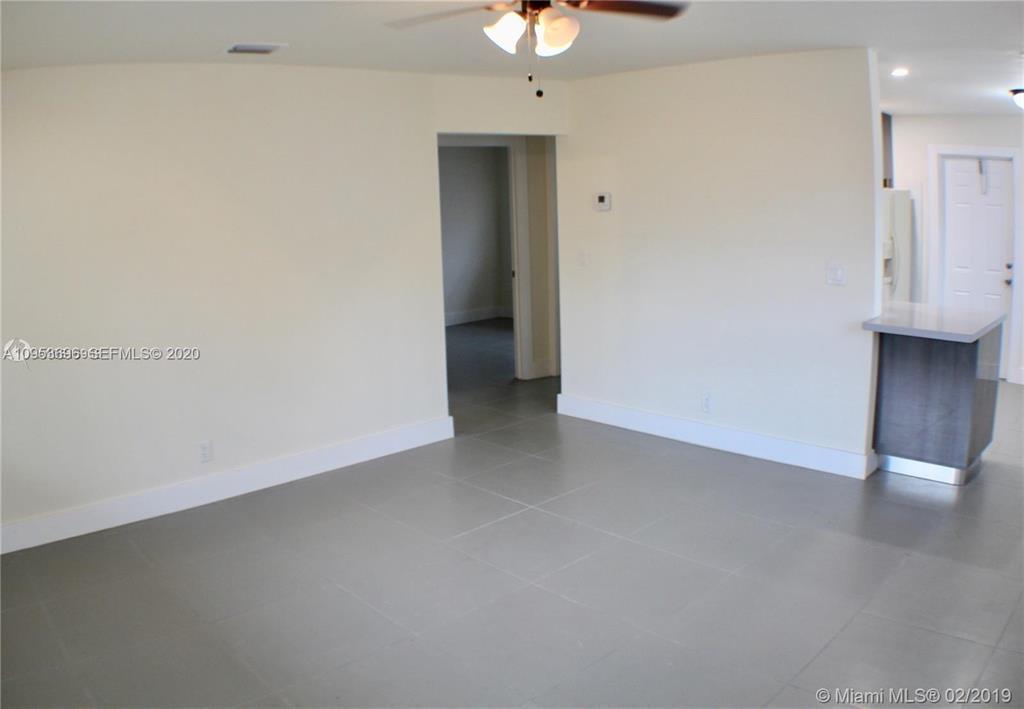An interior view shows a room with light-colored walls, gray tile flooring, and a ceiling fan — 719 SW 7th Street # 2, Hallandale Beach FL 33009, HALLANDALE BEACH, FL