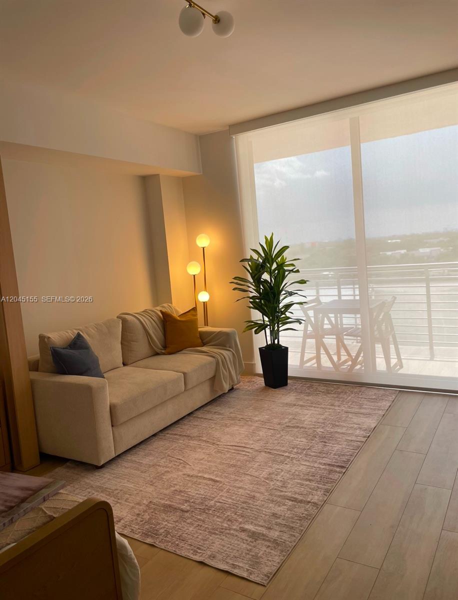 A living room features a beige sofa, a floor lamp, and a large window — 90 NE 32 # 819, Miami FL 33137, MIAMI, FL
