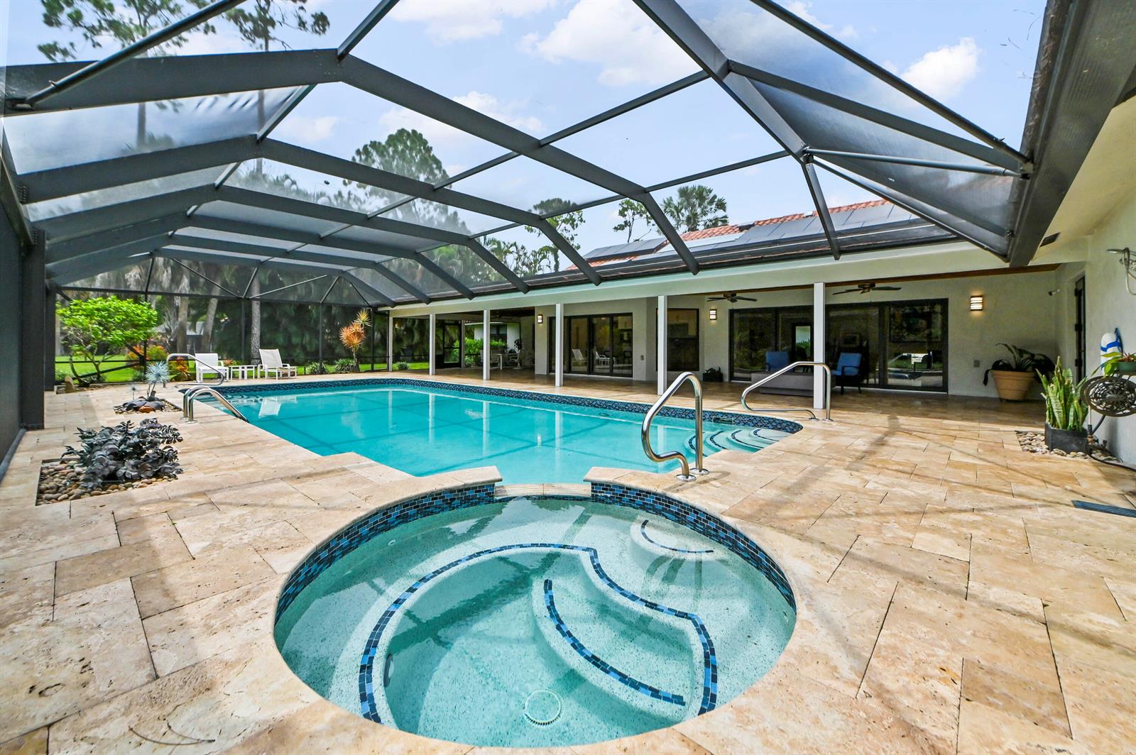 A screened-in patio features a swimming pool, a circular hot tub, and stone tile flooring — 13067 Doubletree Circle, Wellington FL 33414, WELLINGTON, FL