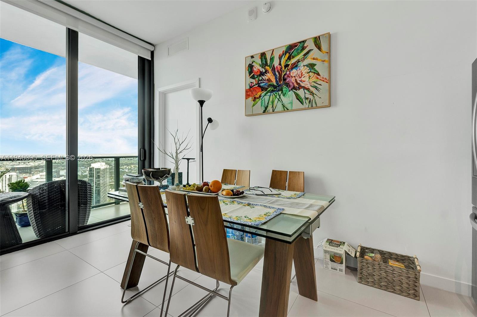 A dining area features a glass-top table, wooden chairs, and a large window with city views — 501 NE 31 # 4305, Miami FL 33137, MIAMI, FL