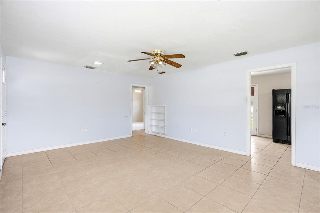 An empty room with light blue walls, beige tile flooring, and a ceiling fan — 701 59TH STREET S, GULFPORT, FL