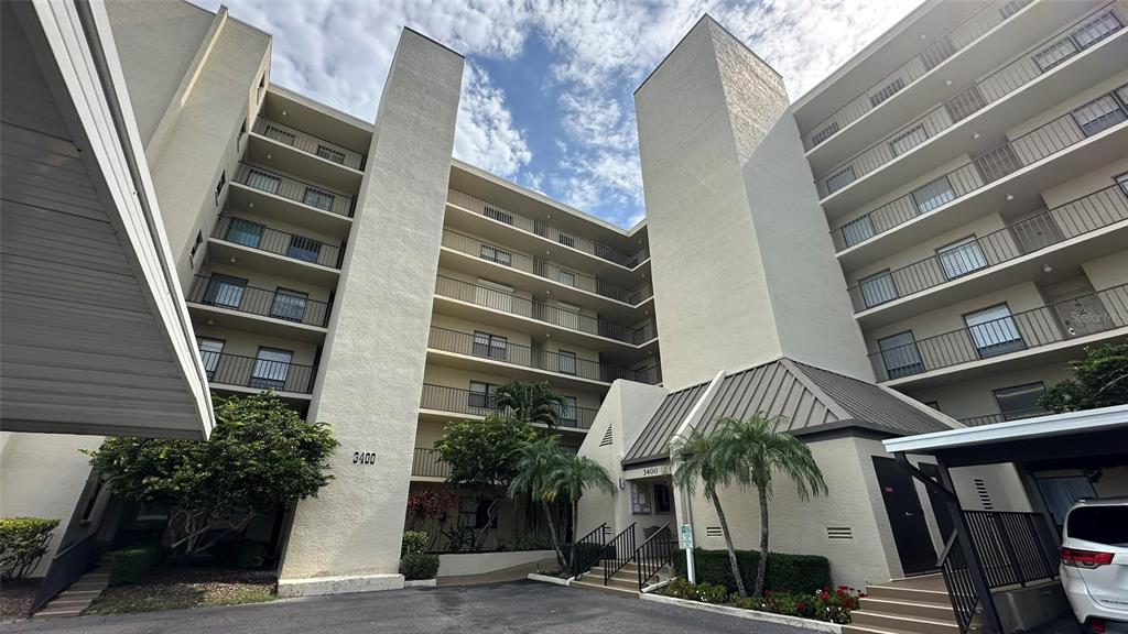 A multi-story apartment building with balconies and a covered entrance area — 3400 COVE CAY DRIVE UNIT 4E, CLEARWATER, FL