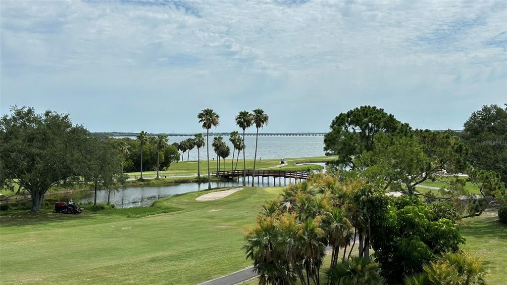 A view of a golf course, a wooden bridge, and a large body of water — 3400 COVE CAY DRIVE UNIT 4E, CLEARWATER, FL