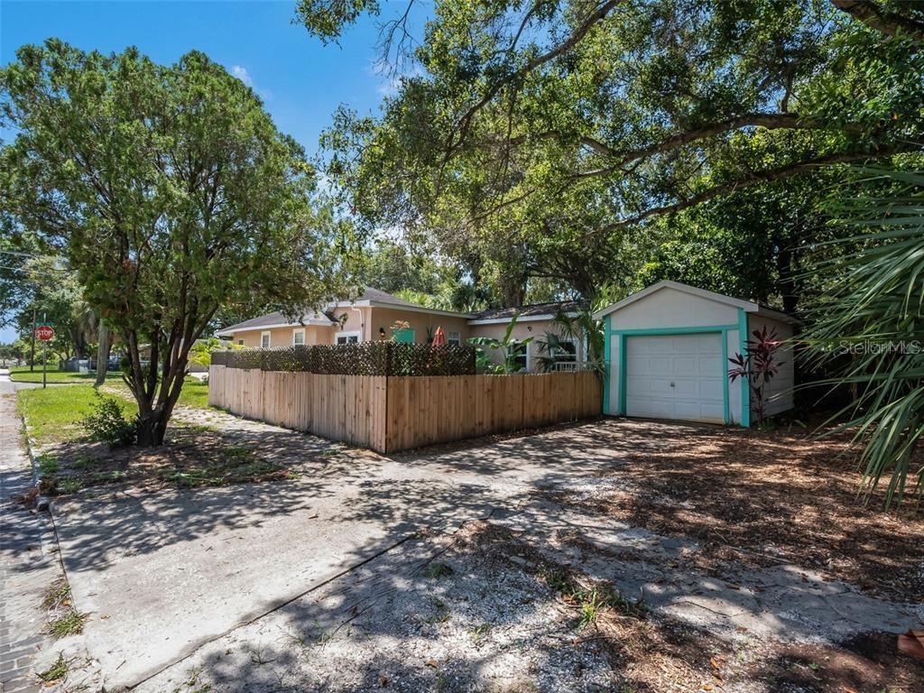 A single-story house with a detached garage and a wooden privacy fence in the yard — 201 35TH STREET S, ST PETERSBURG, FL