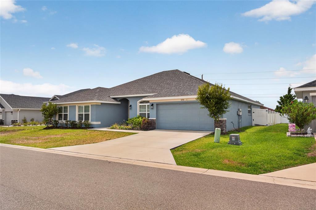 A blue single-story suburban house features a two-car garage and a concrete driveway — 8356 SW 59TH TERRACE, OCALA, FL
