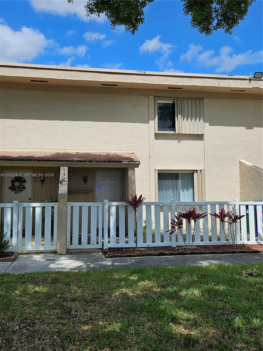 A two-story residential building features a white picket fence enclosing a small front patio — 1419 NW 80th Ave # F, Margate FL 33063, MARGATE, FL