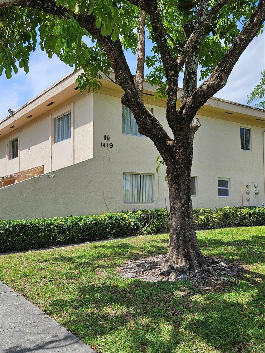 A two-story beige apartment building stands behind a large tree on a grassy lawn — 1419 NW 80th Ave # F, Margate FL 33063, MARGATE, FL