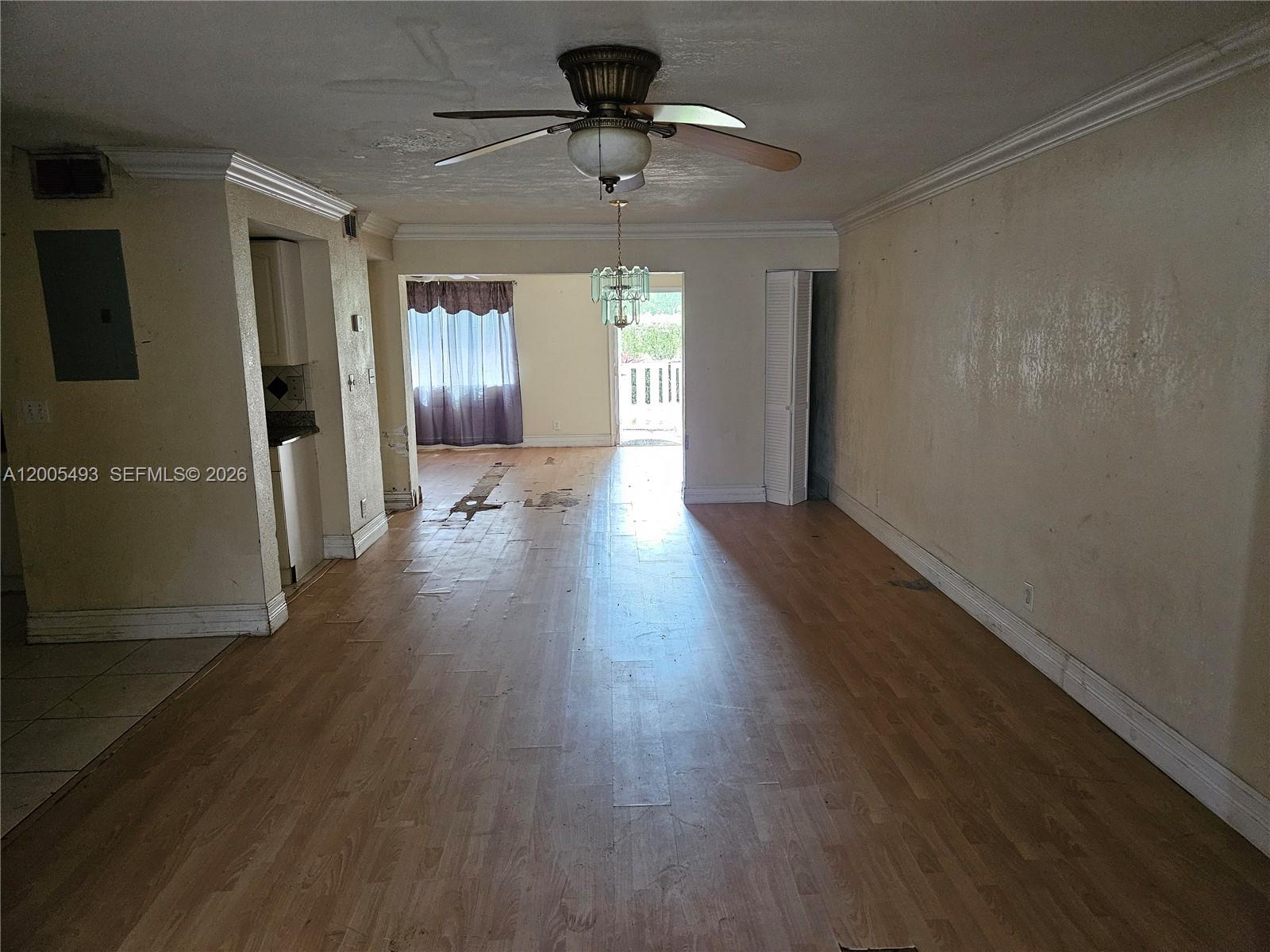 An interior view shows a living room with wood-look flooring, a ceiling fan, and balcony access — 1419 NW 80th Ave # F, Margate FL 33063, MARGATE, FL