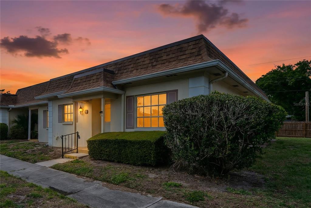 A single-story house exterior with a brown mansard roof at sunset — 1611 S LAKE AVENUE UNIT 1, CLEARWATER, FL