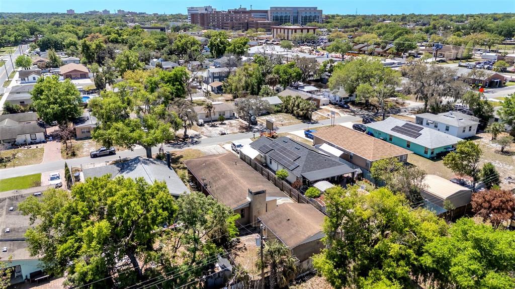 An aerial view shows a residential neighborhood with several single-family homes and surrounding trees — 614 E CRAWFORD STREET, LAKELAND, FL