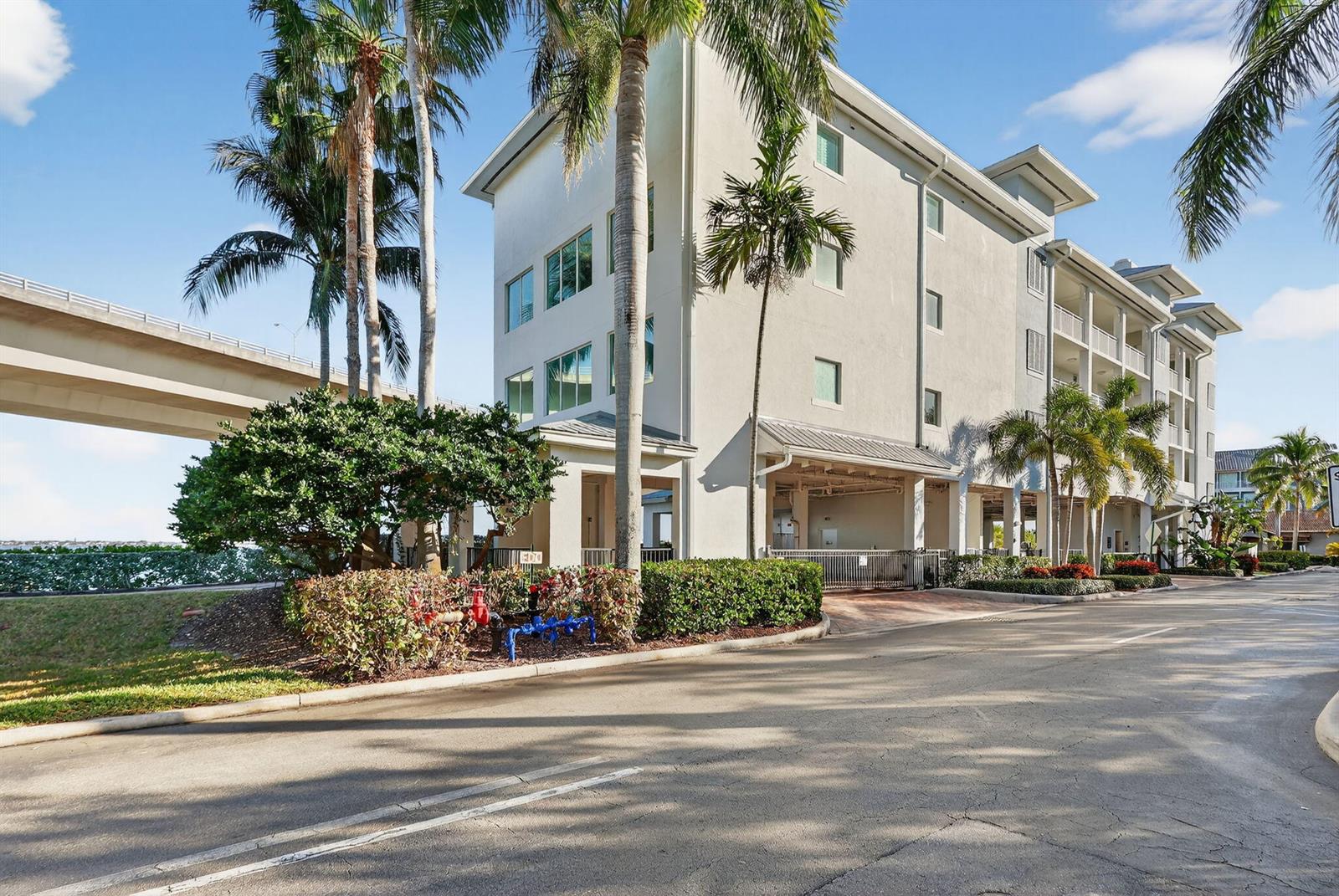 A multi-story building with palm trees and a bridge in the background — 415 NW Flagler Avenue # 403, Stuart FL 34994, STUART, FL