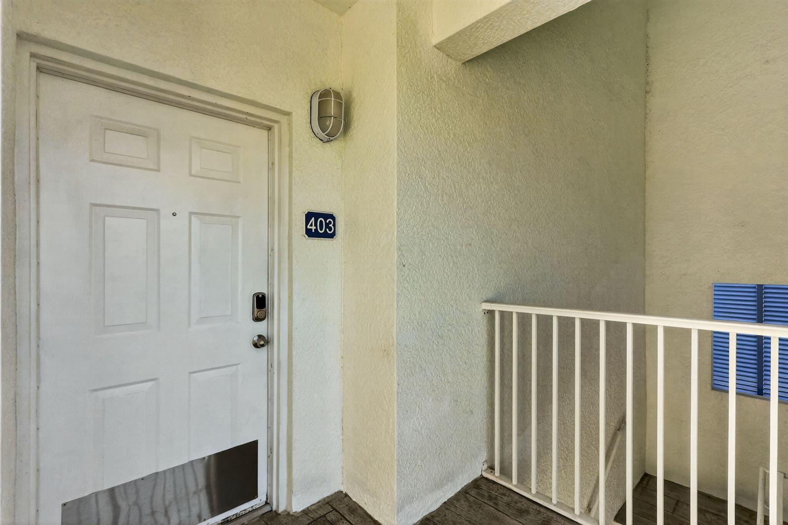 A white apartment door with a metal kickplate is labeled with the number 403 — 415 NW Flagler Avenue # 403, Stuart FL 34994, STUART, FL