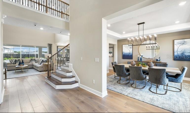A view of a dining room and living area featuring hardwood floors and a staircase — 11270 KINGLY LANE, ODESSA, FL