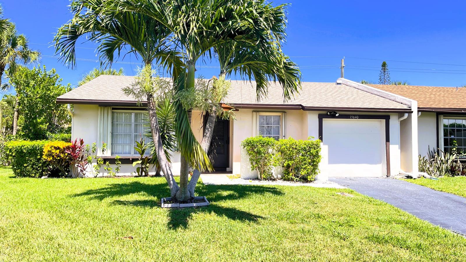 A single-story house with a palm tree in the front yard and a garage — 15640 Bottlebrush Circle, Delray Beach FL 33484, DELRAY BEACH, FL