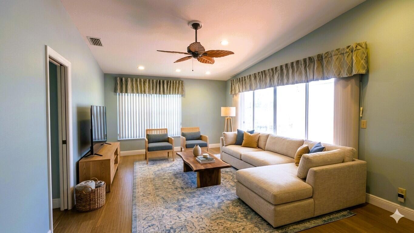 A living room features light blue walls, a sectional sofa, two armchairs, and a ceiling fan — 15640 Bottlebrush Circle, Delray Beach FL 33484, DELRAY BEACH, FL