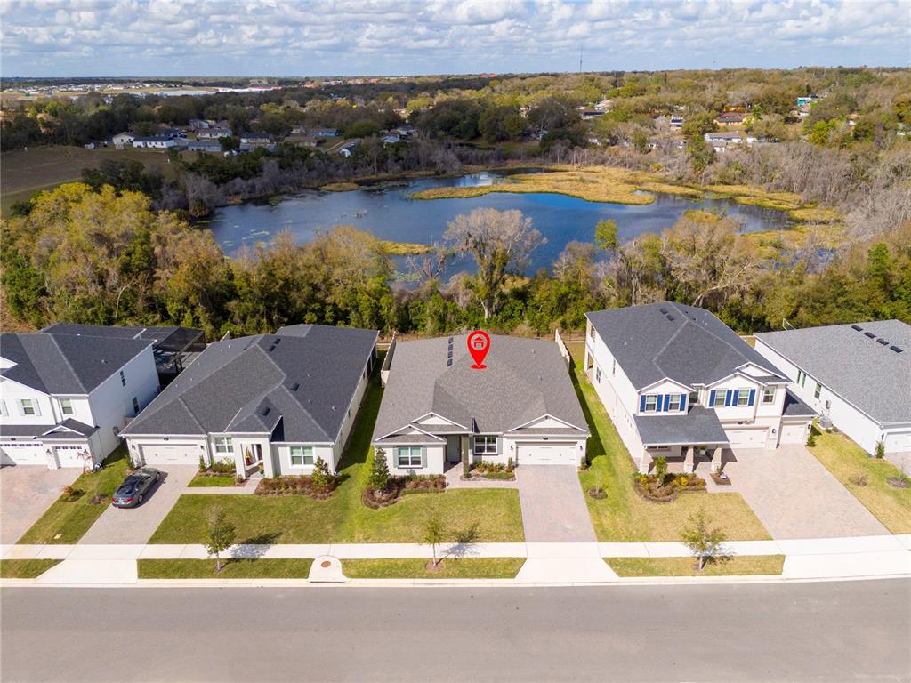 An aerial view shows a suburban house with a red location pin on its roof — 734 CREEPING FIG STREET, APOPKA, FL