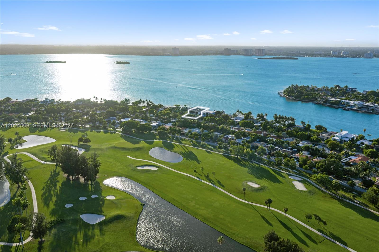 An aerial view shows a waterfront house situated next to a golf course — 857 N Shore Dr, Miami Beach FL 33141, MIAMI BEACH, FL
