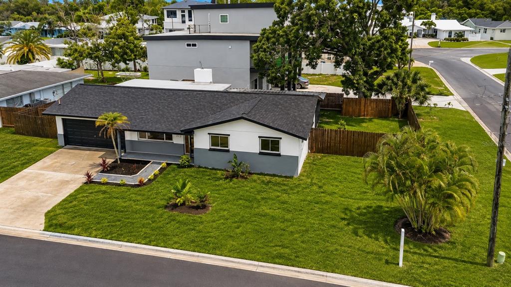An aerial view of a single-story house with a dark roof and a grassy yard — 212 DRIFTWOOD PLACE, PALM HARBOR, FL