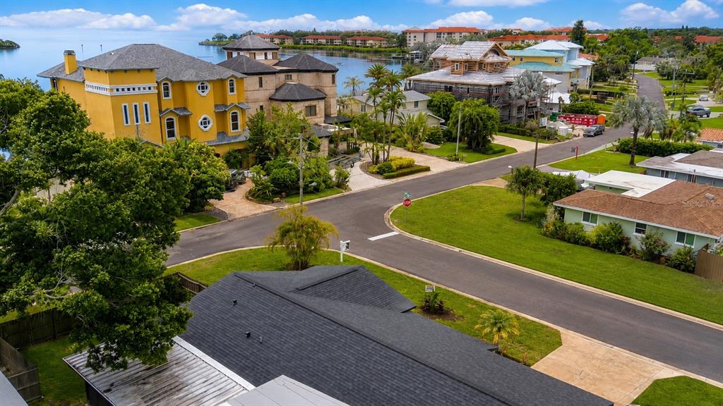 An aerial view shows a yellow multi-story house, a construction site, and suburban streets — 212 DRIFTWOOD PLACE, PALM HARBOR, FL