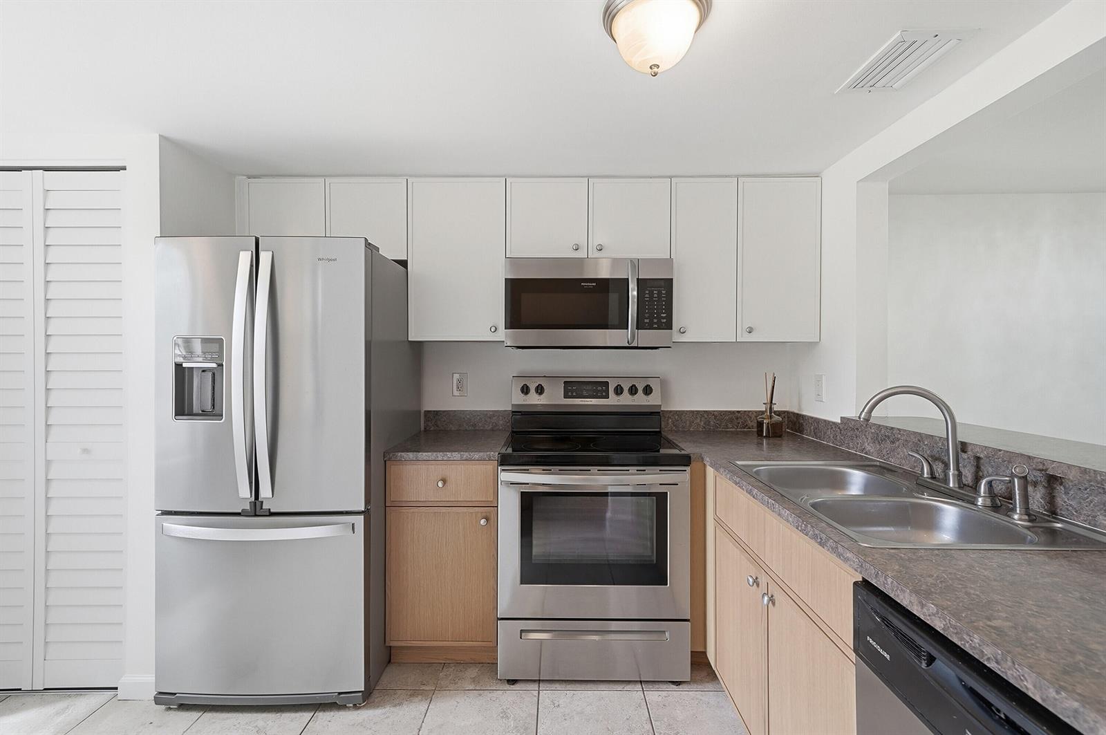 A kitchen features stainless steel appliances, light wood lower cabinets, white upper cabinets, and countertops — 3832 NW 90th Avenue # 3832, Sunrise FL 33351, SUNRISE, FL