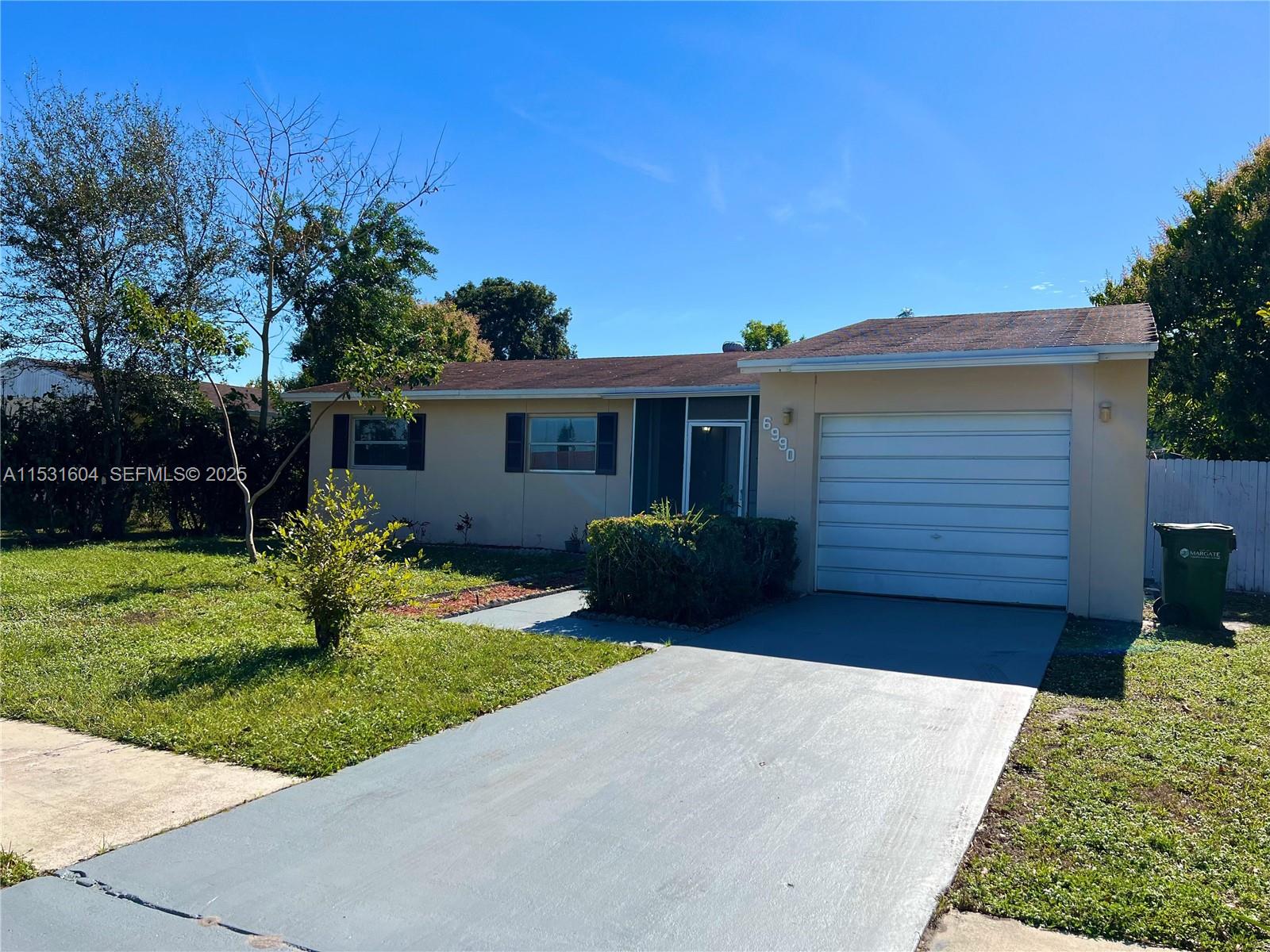 A single-story house with a beige exterior, a one-car garage, and a concrete driveway — 6990 SW 1st St, Margate FL 33068, MARGATE, FL
