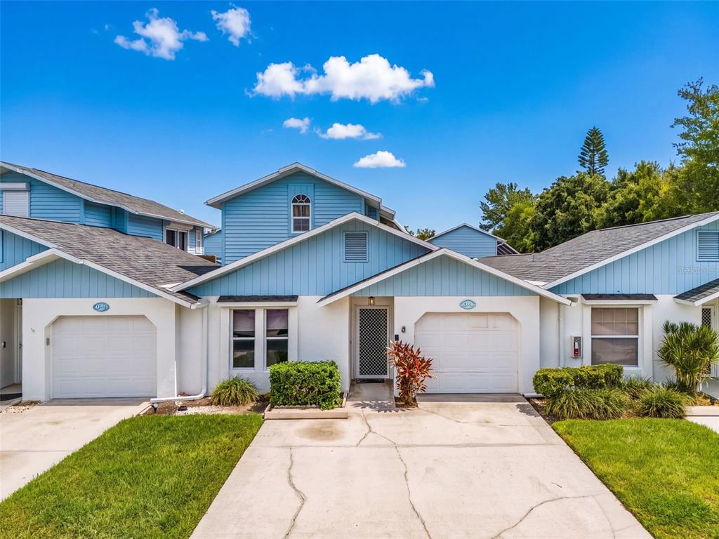 A two-story blue and white townhouse with two garages and a central front entrance — 13721 MARKHAM LANE UNIT 4, FORT MYERS, FL
