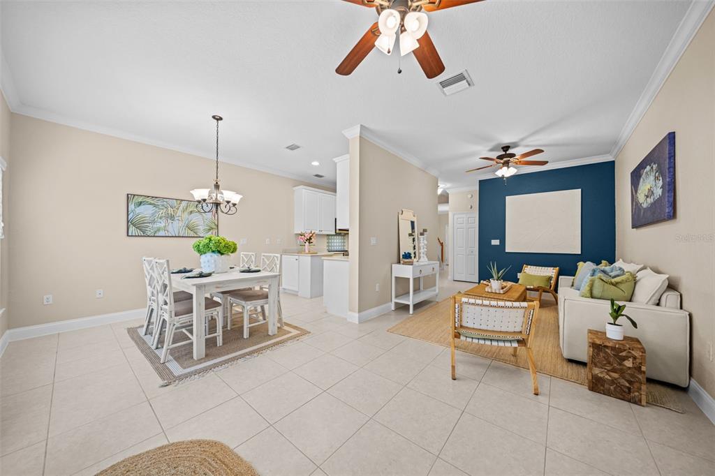 An open-concept living and dining area features tile flooring, ceiling fans, and a blue accent wall — 202 KING NEPTUNE LANE UNIT 202, CAPE CANAVERAL, FL