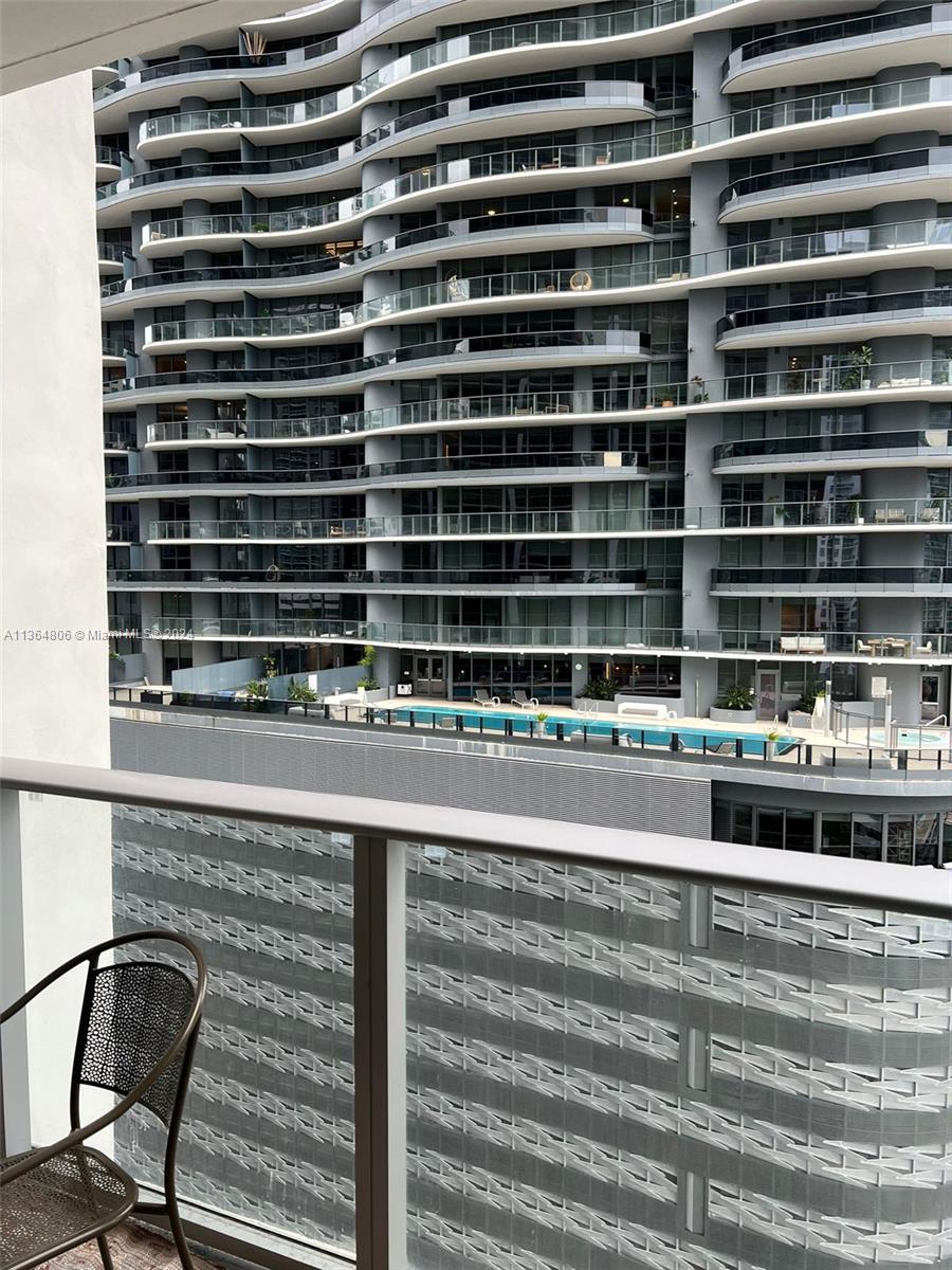 A balcony view overlooks a modern high-rise apartment building with a swimming pool below — 1010 Brickell Ave # 2010, Miami FL 33131, MIAMI, FL