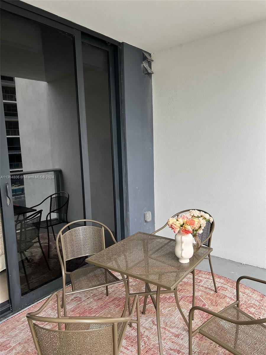 A balcony features a metal table and chairs set on a patterned rug — 1010 Brickell Ave # 2010, Miami FL 33131, MIAMI, FL
