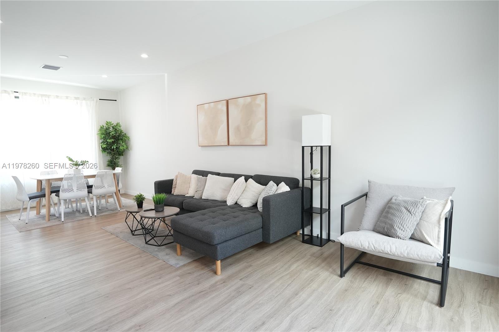 A living room features a dark gray sectional sofa, a light gray armchair, and dining area — 211 SE 4th St # 3, Hallandale Beach FL 33009, HALLANDALE BEACH, FL