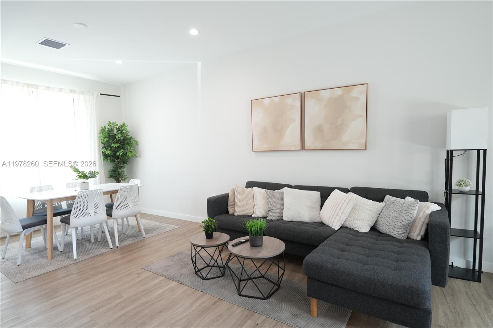 A living and dining area features a gray sectional sofa, two coffee tables, and chairs — 211 SE 4th St # 3, Hallandale Beach FL 33009, HALLANDALE BEACH, FL