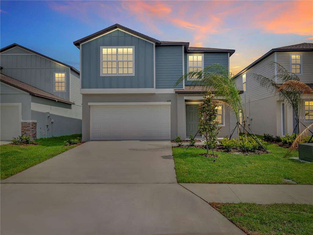 A two-story suburban house with a blue upper facade, gray lower level, and two-car garage — 6115 BLUE PALOMA COURT, PALMETTO, FL