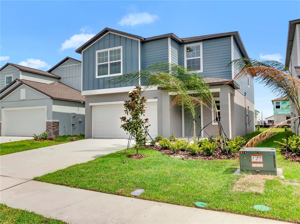 A two-story house with blue siding, a gray stucco lower level, and a two-car garage — 6115 BLUE PALOMA COURT, PALMETTO, FL