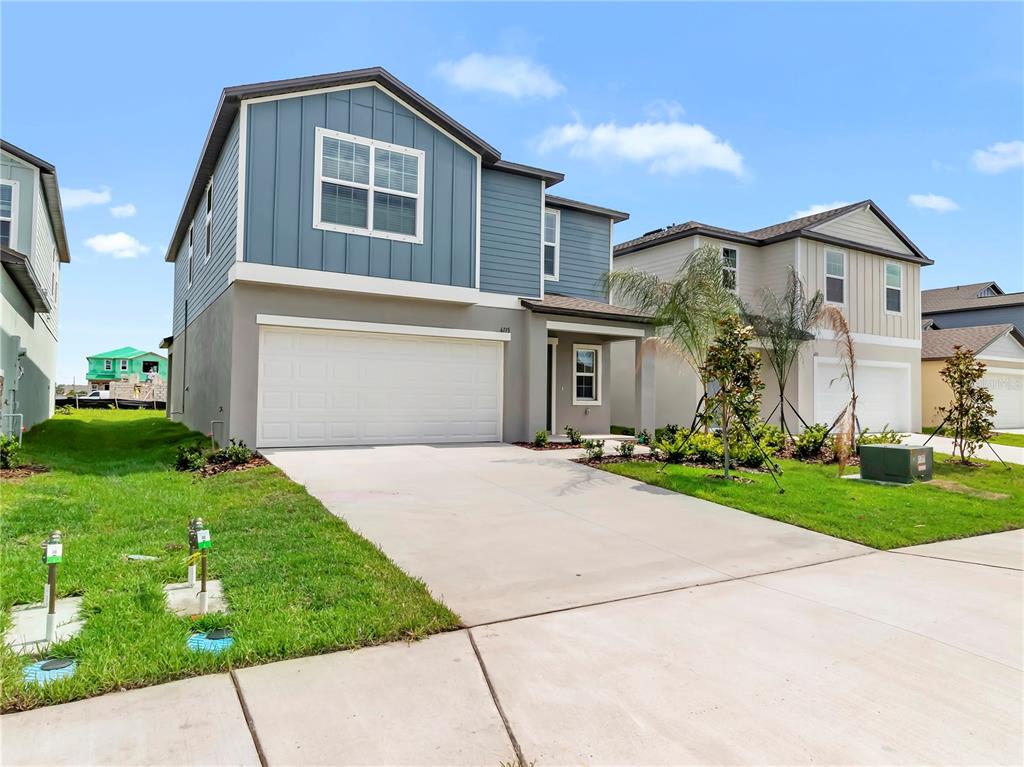 A two-story house with a blue vertical-siding upper level and a gray stucco lower level — 6115 BLUE PALOMA COURT, PALMETTO, FL