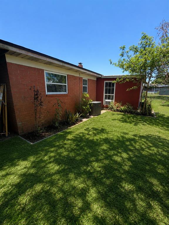 A red brick house exterior with a green lawn, an air conditioning unit, and trees — 5801 BROOKGREEN AVENUE, ORLANDO, FL