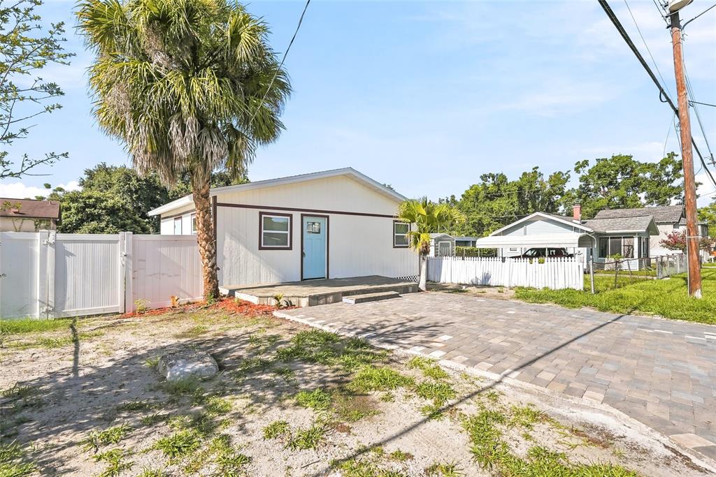 A single-story house with a light-colored exterior, a blue front door, and a paved driveway — 1313 E SITKA STREET, TAMPA, FL
