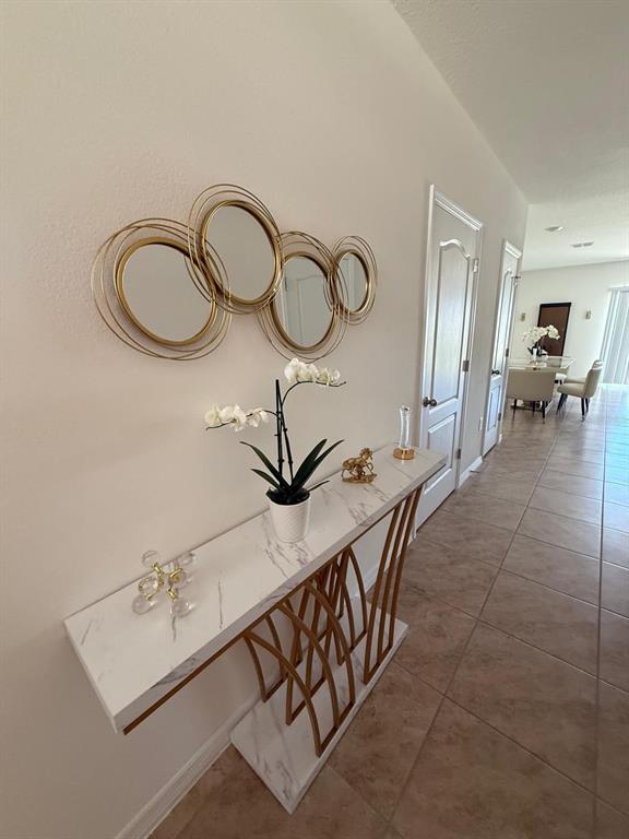 A hallway features a white marble console table with gold legs and a wall-mounted mirror — 1419 PLANK PLACE, DAVENPORT, FL