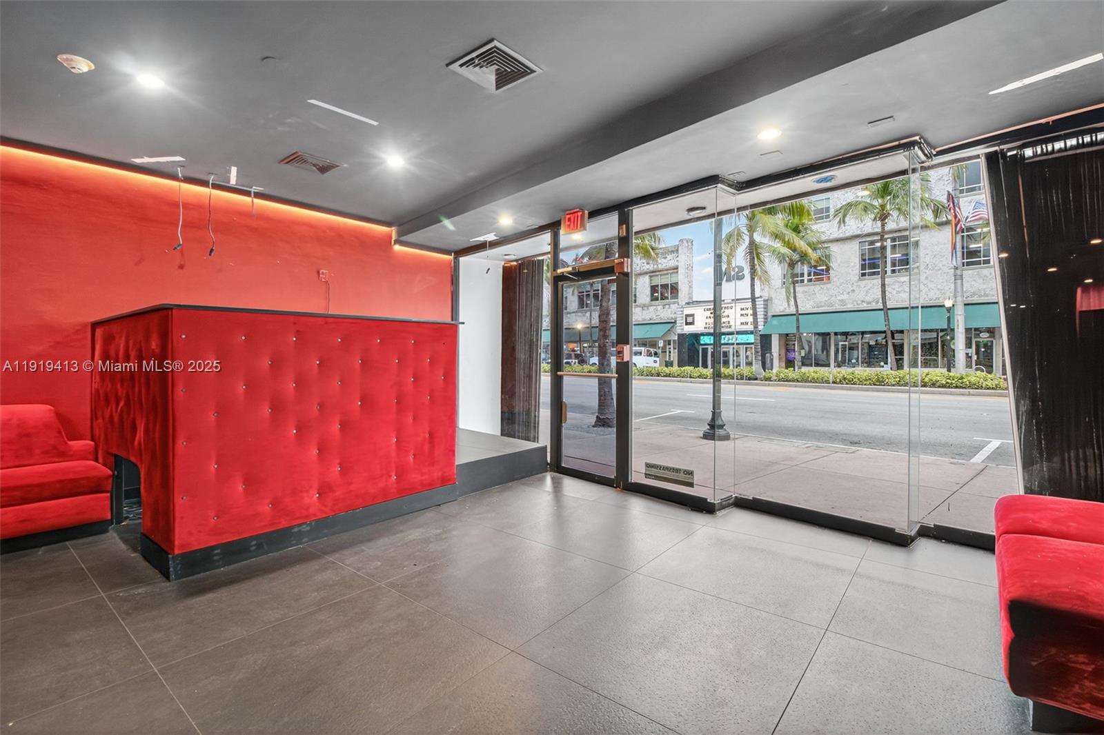 A commercial space features red tufted walls, matching seating, and large glass storefront windows — 1218 Washington AVE, Miami Beach FL 33139, MIAMI BEACH, FL