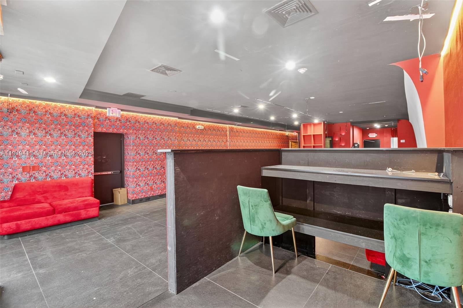 A room features patterned red wallpaper, a red sofa, and a dark wooden bar area — 1218 Washington AVE, Miami Beach FL 33139, MIAMI BEACH, FL