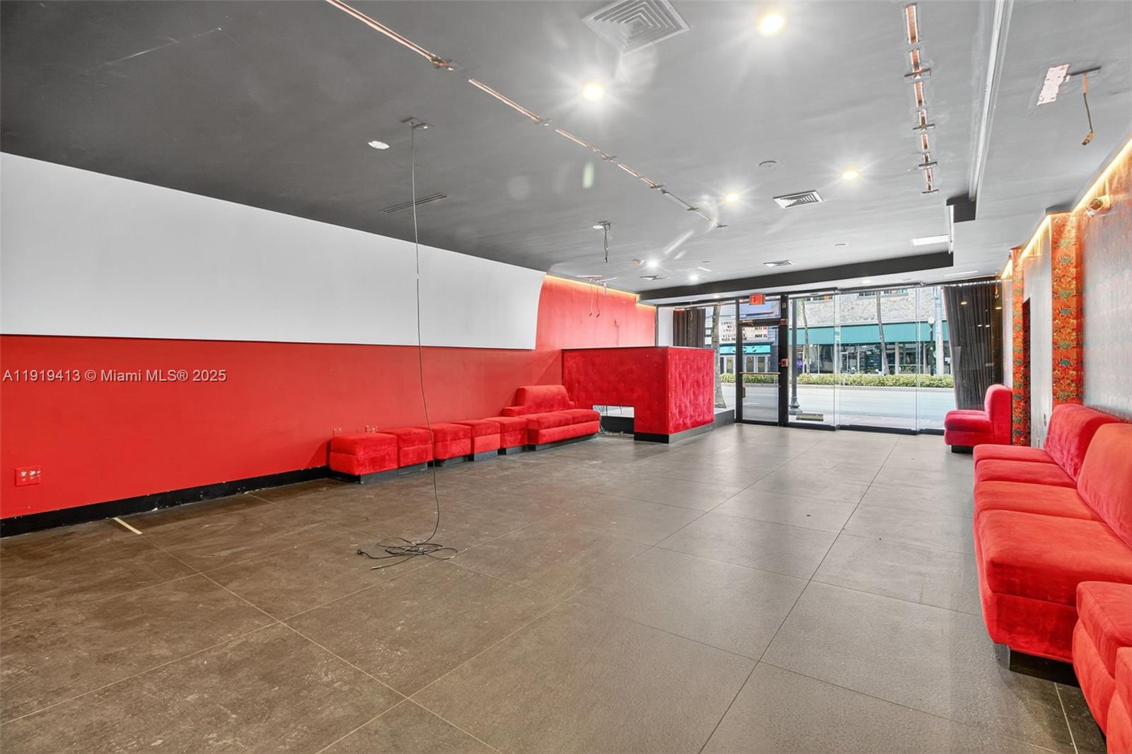 An empty commercial space features red velvet seating, dark tile floors, and red walls — 1218 Washington AVE, Miami Beach FL 33139, MIAMI BEACH, FL