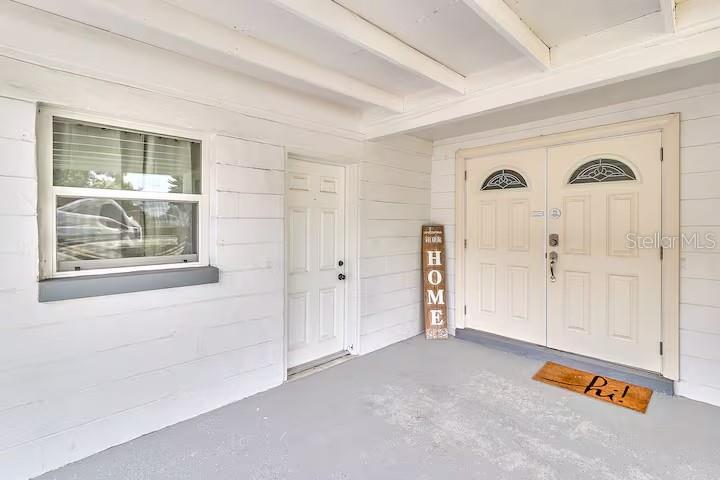 A white concrete block house features a covered carport with a gray painted floor — 2804 N 33RD STREET, TAMPA, FL